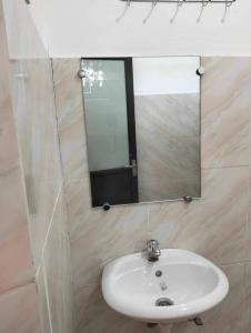 a bathroom with a sink and a mirror at Mario's White House in Langi-langiban