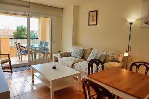 ein Wohnzimmer mit einem Sofa und einem Tisch in der Unterkunft Isla de Altea Sol Y Mar in Altea
