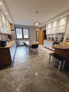 a large kitchen with a table and chairs in it at Apartament u Rybaka in Sędki