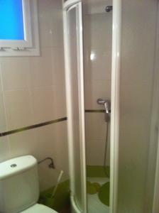 a bathroom with a toilet and a glass shower at Bonito y tranquilo apartamento en Nervión in Seville