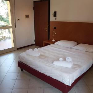 a bedroom with a large bed with towels on it at Il Rampicante-Monticelli Terme in Monticelli Terme