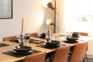 una mesa de madera con sillas y cuencos negros. en Industrial Apartment für 8 - Gemeinsam auf Reisen, en Schwetzingen
