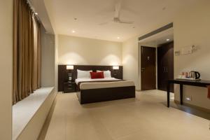 a hotel room with a bed and a desk at Freesia Residency by Express Inn in Nashik