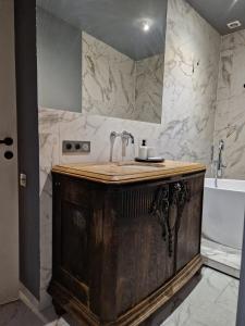 La salle de bains est pourvue d'un lavabo en bois et d'une baignoire. dans l'établissement Riverside Retreat on Parkowa, à Wrocław