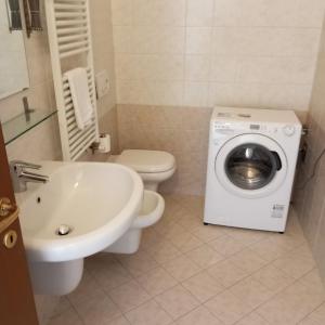 uma casa de banho com um WC e uma máquina de lavar roupa em Il Rampicante-Monticelli Terme em Monticelli Terme
