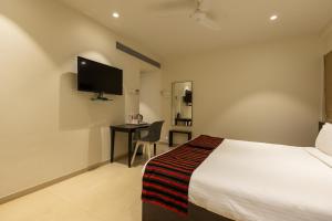 ein Hotelzimmer mit einem Bett und einem Schreibtisch in der Unterkunft Freesia Residency by Express Inn in Nashik