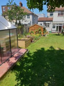 a backyard with a glass house in the yard at Rooms at EEJ homes in London