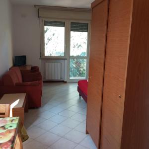 uma sala de estar com um sofá vermelho e uma janela em Il Rampicante-Monticelli Terme em Monticelli Terme