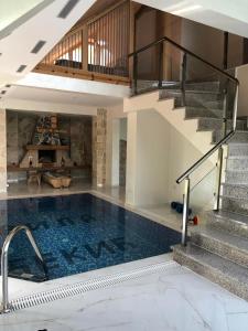 Andrijevica的住宿－Vila Djekic，一座带楼梯的房屋内的游泳池