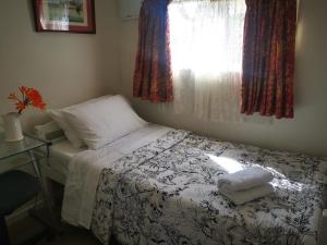 a small bedroom with a bed and a window at Warm little house at Wesley in Auckland