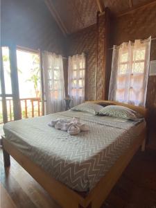 a bedroom with a bed with slippers on it at Hola Beach Resort in Siquijor