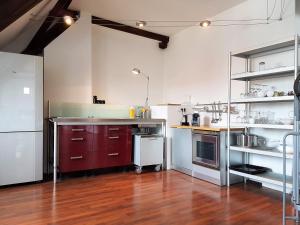 a kitchen with red cabinets and a wooden floor at Haus Pinkafeld Top 2 in Pinkafeld
