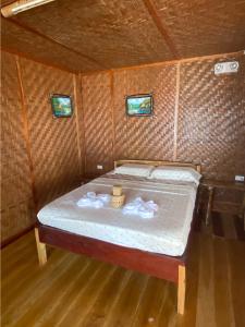 uma cama num pequeno quarto com duas janelas em Hola Beach Resort em Siquijor