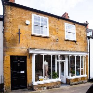an old wooden building with a dress in a window at 1 Bedroom (+sofa bed) Flat in Ilminster, Somerset in Ilminster