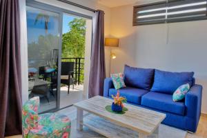 a living room with a blue couch and a table at BLUE VELVET in Nosy Be