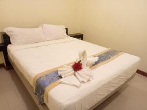 ein weißes Bett mit einer Blume darüber in der Unterkunft ไลอ้อน โฮเทล in Chumphon