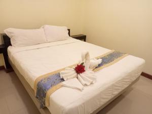 a white bed with a flower on top of it at ไลอ้อน โฮเทล in Chumphon