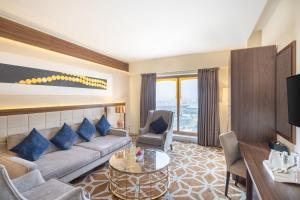 Blue Coral Hotel في مكة المكرمة: غرفة معيشة مع أريكة وطاولة