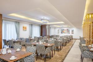un restaurante con mesas y sillas en una habitación en Blue Coral Hotel, en La Meca