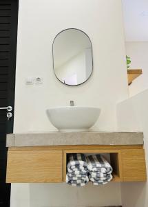 y baño con lavabo y espejo. en Eleven villa 1 en Pangandaran
