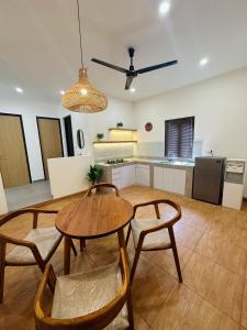 sala de estar con mesa y sillas y cocina en Eleven villa 1 en Pangandaran