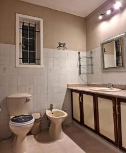 uma casa de banho com um WC, um lavatório e um espelho. em R Garden Studio 2 moderne pour couple dans un cadre relaxant et confortable em Port Louis
