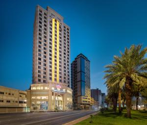 Blue Coral Hotel في مكة المكرمة: مبنى طويل في مدينة بها أشجار النخيل