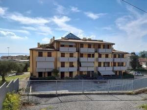 a large building with a fence in front of it at Caba Holiday Bardolino Pasubio in Bardolino