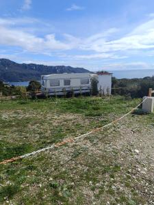 una caravana estacionada en un campo junto al agua en Fox Caravan, en Afionas