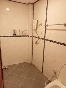 ein Bad mit einer Dusche und einem WC in der Unterkunft ไลอ้อน โฮเทล in Chumphon