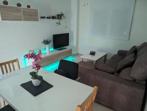 a living room with a table and a couch at Apartamento Céntrico Churriana in Churriana de la Vega