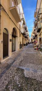 a cobblestone street in a city with buildings at Sweet Home Cefalù in Cefalù