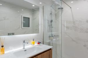 biała łazienka z umywalką i prysznicem w obiekcie Athens Oasis - Timeless comfort at the Acropolis w Atenach