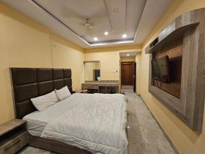 a bedroom with a bed and a flat screen tv at Hotel Aditya Inn in Varanasi