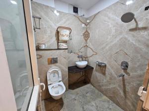 a bathroom with a toilet and a sink at Hotel Aditya Inn in Varanasi