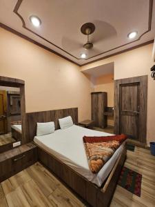 uma cama grande num quarto com pisos em madeira em Hotel Aditya Inn em Varanasi