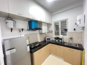 a kitchen with a refrigerator and a sink at Sri Sai 3 BHK Home in Kelambākkam