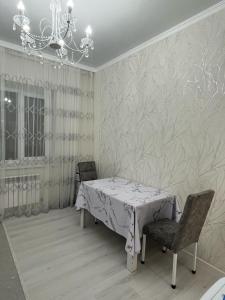 a dining room with a table and chairs and a chandelier at 3-комнатные Апартаменты LUX in Taraz