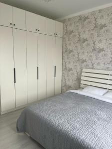 um quarto com uma cama e armários brancos em 3-комнатные Апартаменты LUX em Taraz