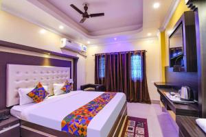 a bedroom with a bed and a desk in a room at Goroomgo Bollywood Sea View Room Puri in Puri