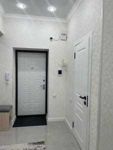塔拉茲的住宿－3-комнатные Апартаменты LUX，走廊设有白色门和水槽