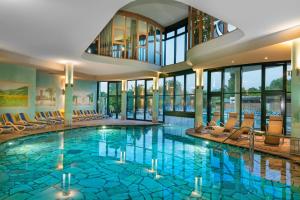 a large swimming pool with chairs in a building at Atlantic Terme Natural Spa & Hotel in Abano Terme