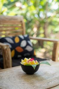 un tazón de flores sentado en una mesa en Jepun Didulu Cottages, en Candidasa