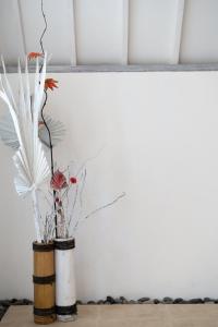 a vase with flowers in it on a table at Jepun Didulu Cottages in Candidasa