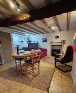 sala de estar con mesa y sofá rojo en La Vieille Ferme, en Donnay