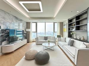salon z białymi meblami i telewizorem z płaskim ekranem w obiekcie Brown Suites Busan Station w Pusanie