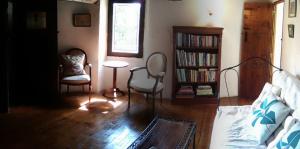 a living room with two chairs and a book shelf at Quaint and original loft room 