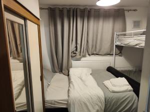 a small room with a bed in front of a window at home from home in Erith