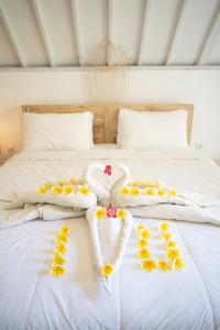 Una cama blanca con toallas y flores. en Jepun Didulu Cottages, en Candidasa