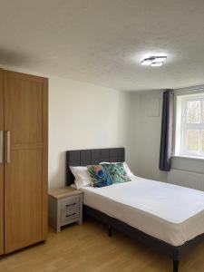 Schlafzimmer mit einem Bett und einem Fenster in der Unterkunft 2Bed Cozy Spacious apartment - 15min to Canary Wharf O2 Excel Central London in London
